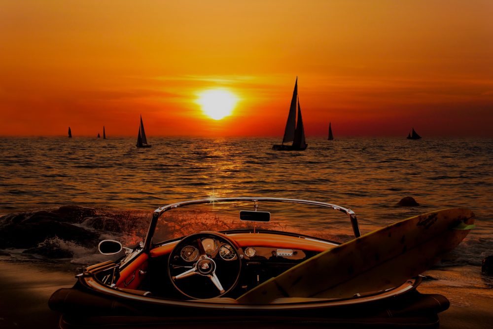 convertible by water with surfboard