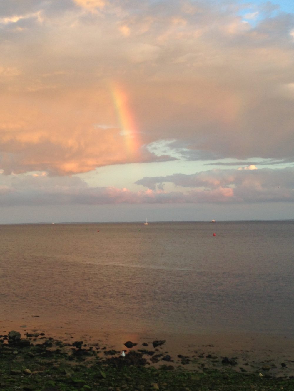 rainbow in clouds over water